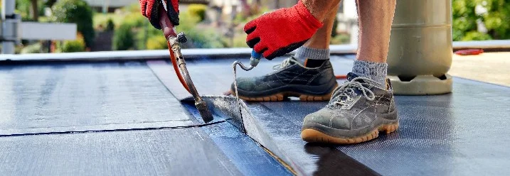 Person verwendet Gasbrenner auf Dach